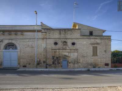 Si tratta della facciata dell�antica masseria, al centro della quale � incastonato il prospetto neoclassico della chiesa della Santissima Trinit�